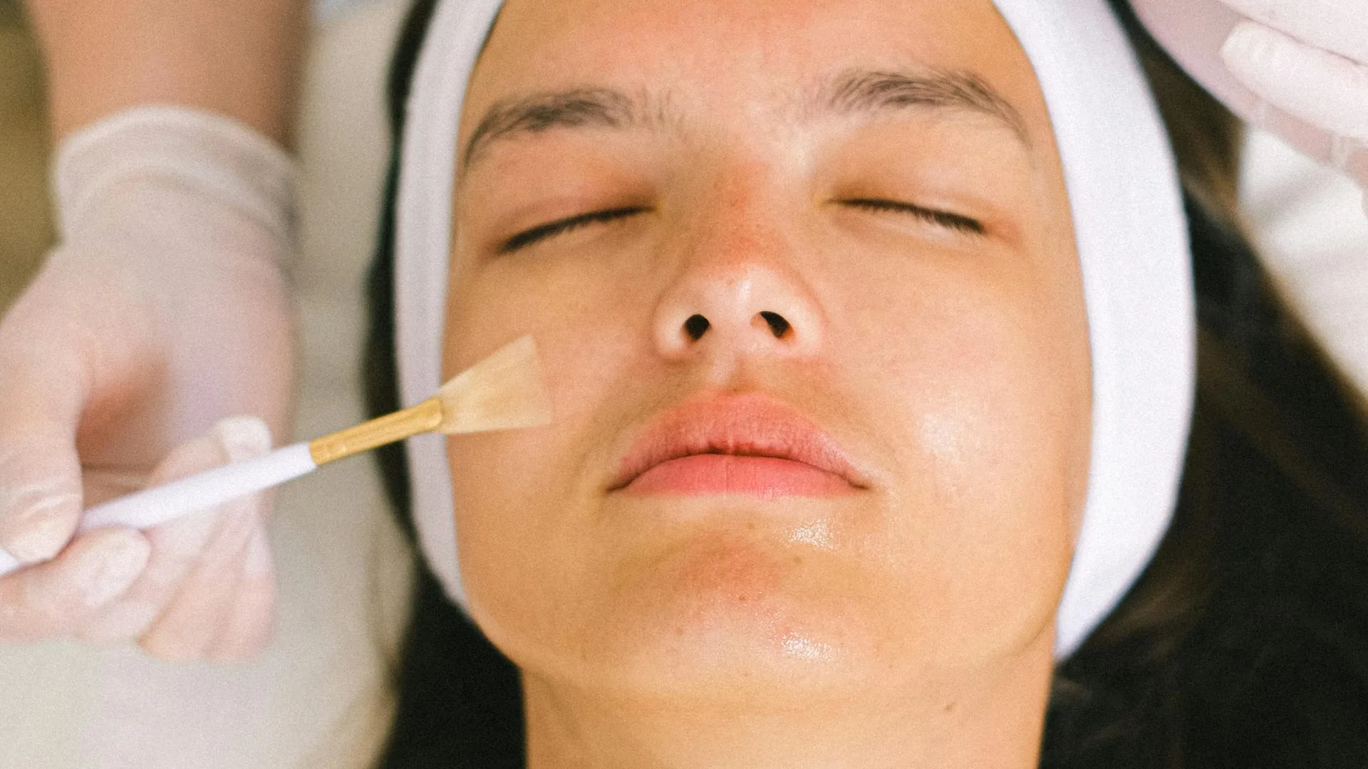 Esthetician applying facial treatment in a serene suite